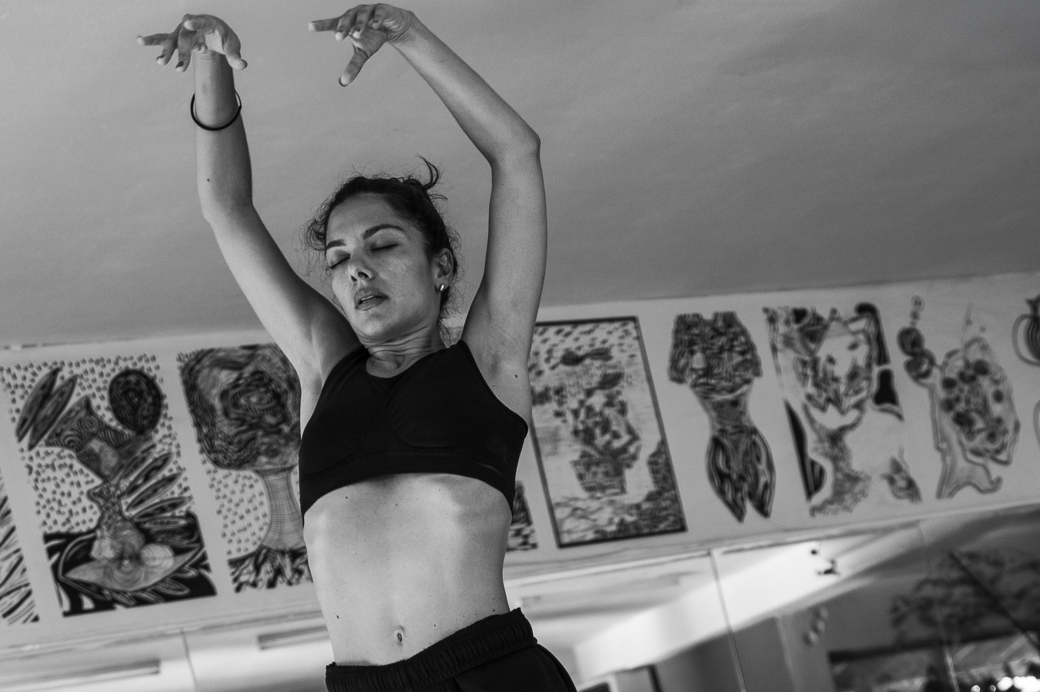 Vilelmini dancing with arms raised, eyes closed, captured in a moment of movement and concentration.