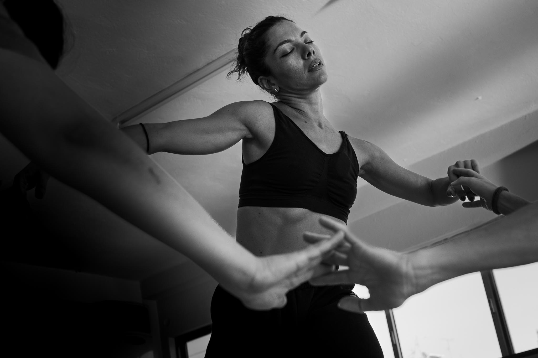 Vilelmini moves in unison with the group — a dynamic passage of gestures, breath, and instinctive motion. A moment where boundaries dissolve into shared rhythm.